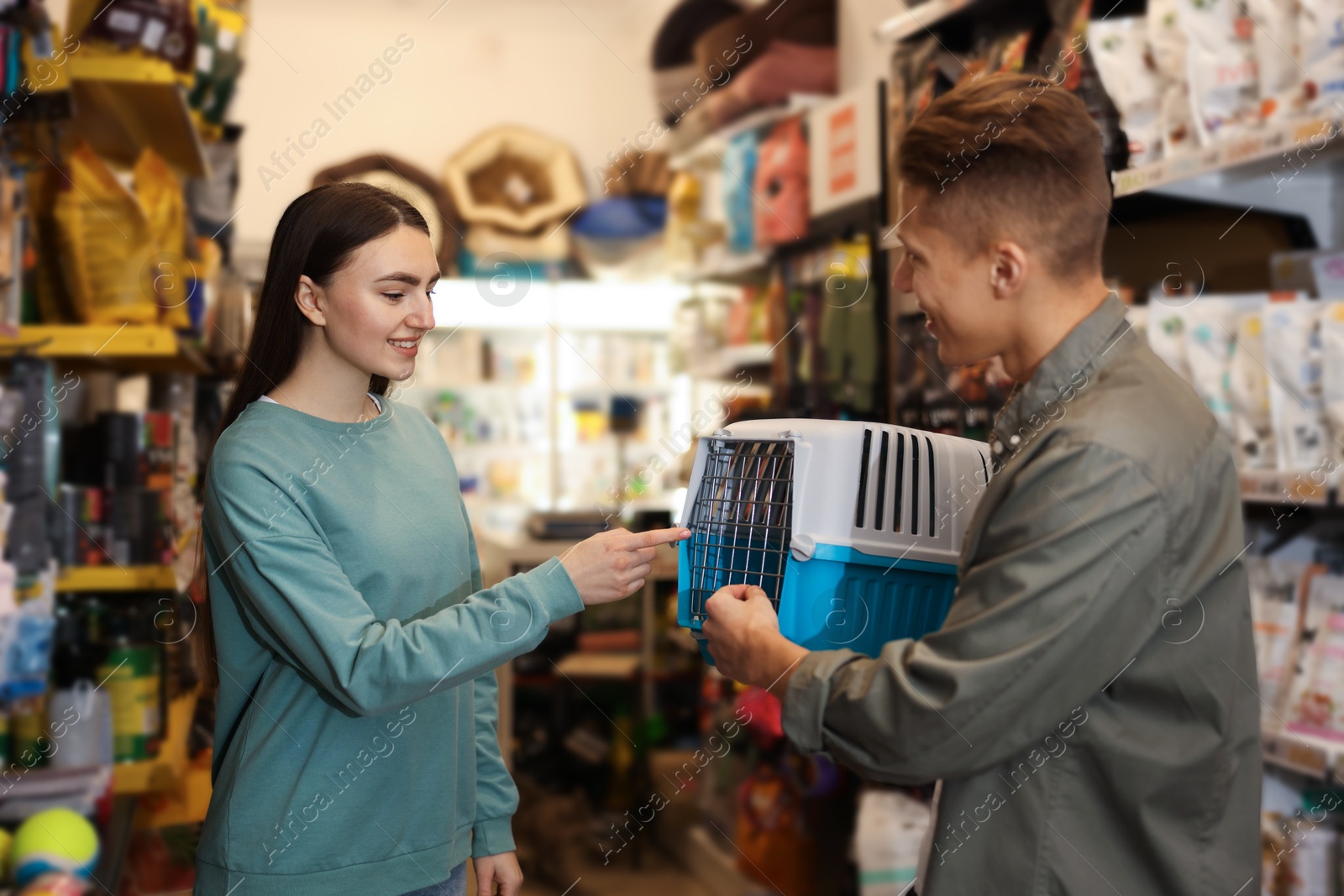 Photo of Happy couple choosing carrier in pet shop