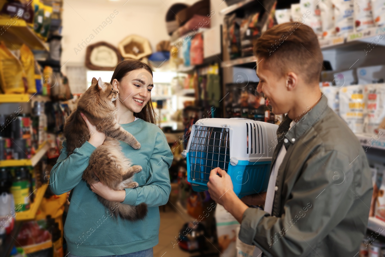 Photo of Couple choosing carrier for their cute cat in pet shop