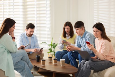 Internet addiction. Group of friends with gadgets and coffee at table indoors