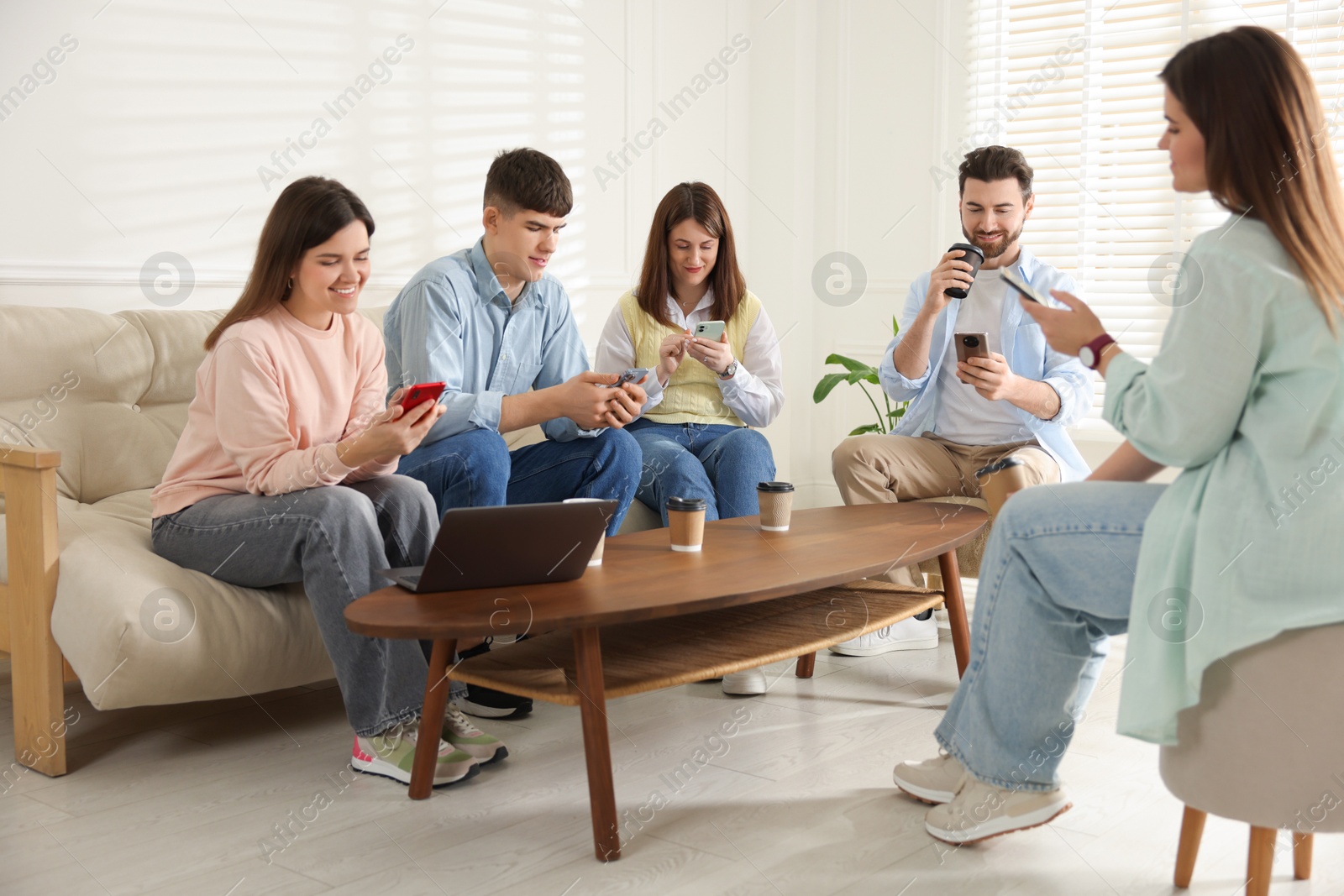 Photo of Internet addiction. Group of friends with gadgets and coffee at table indoors