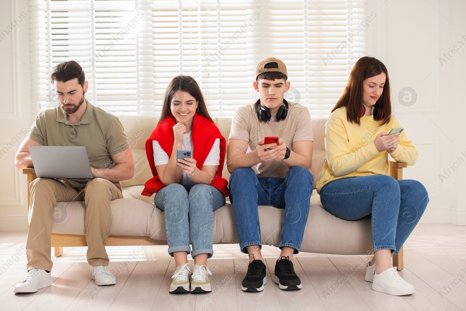 Photo of Internet addiction. Group of people with gadgets on sofa indoors