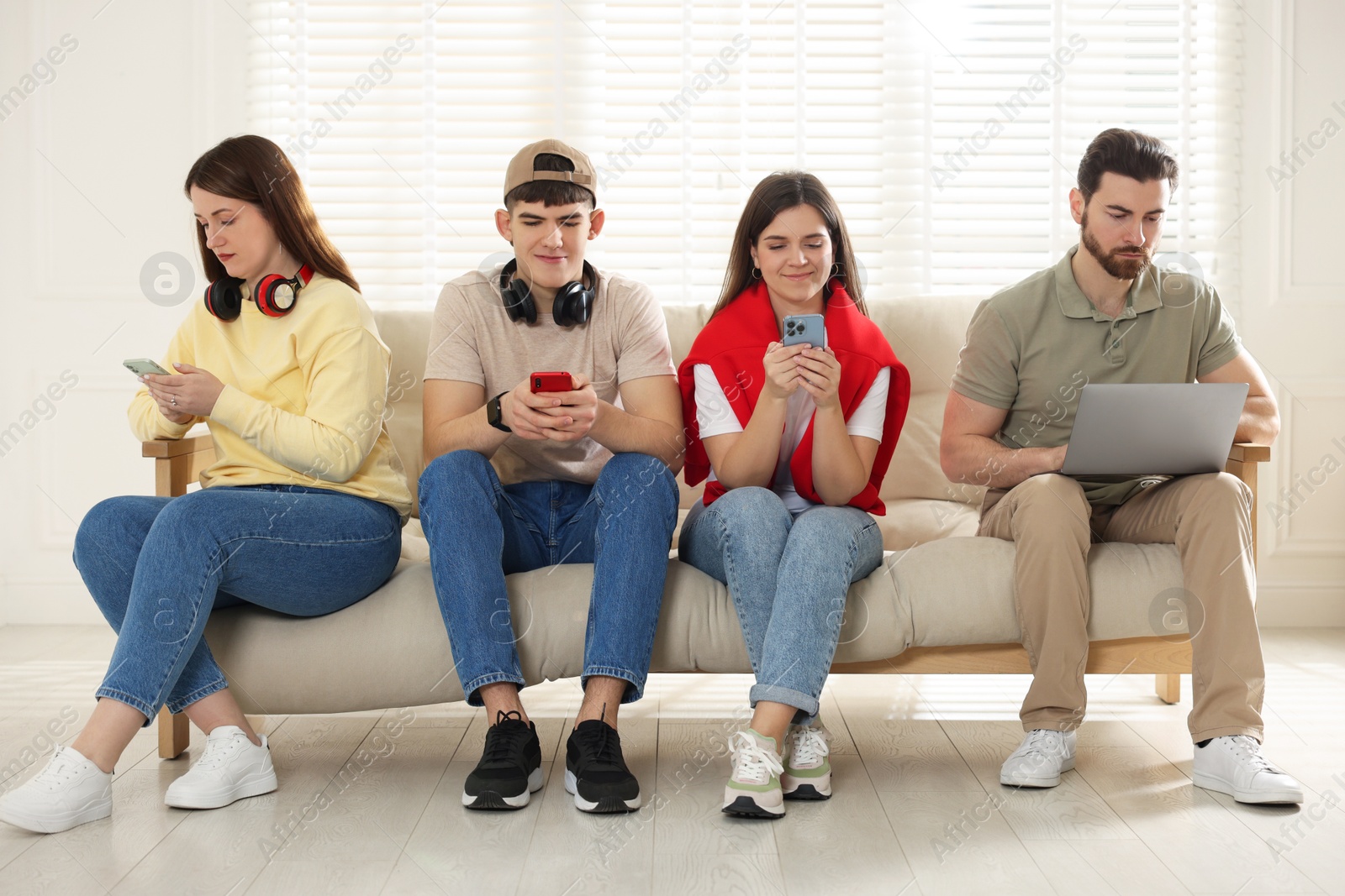 Photo of Internet addiction. Group of people with gadgets on sofa indoors