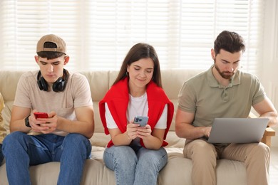 Photo of Internet addiction. Group of people with gadgets on sofa indoors