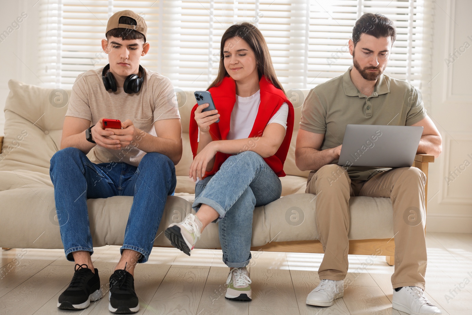 Photo of Internet addiction. Group of people with gadgets on sofa indoors