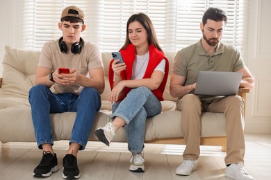 Photo of Internet addiction. Group of people with gadgets on sofa indoors