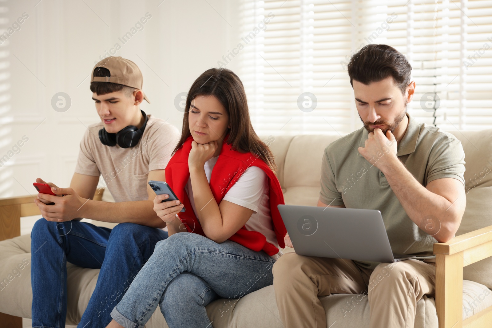 Photo of Internet addiction. Group of people with gadgets on sofa indoors