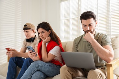 Photo of Internet addiction. Group of people with gadgets on sofa indoors