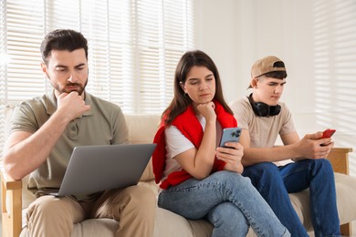 Photo of Internet addiction. Group of people with gadgets on sofa indoors