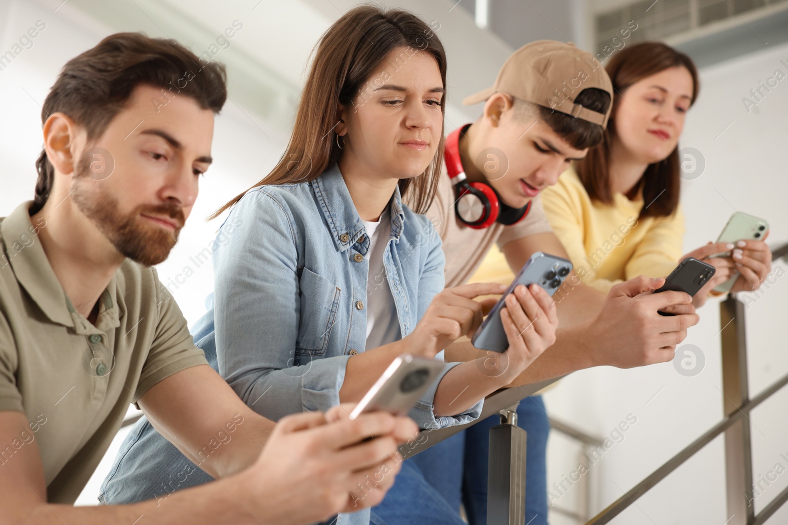 Photo of Internet addiction. Group of people with smartphones on stairs indoors