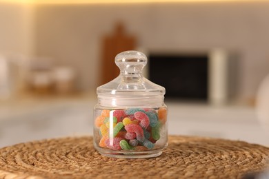 Photo of Gummy candies in glass jar on white table indoors