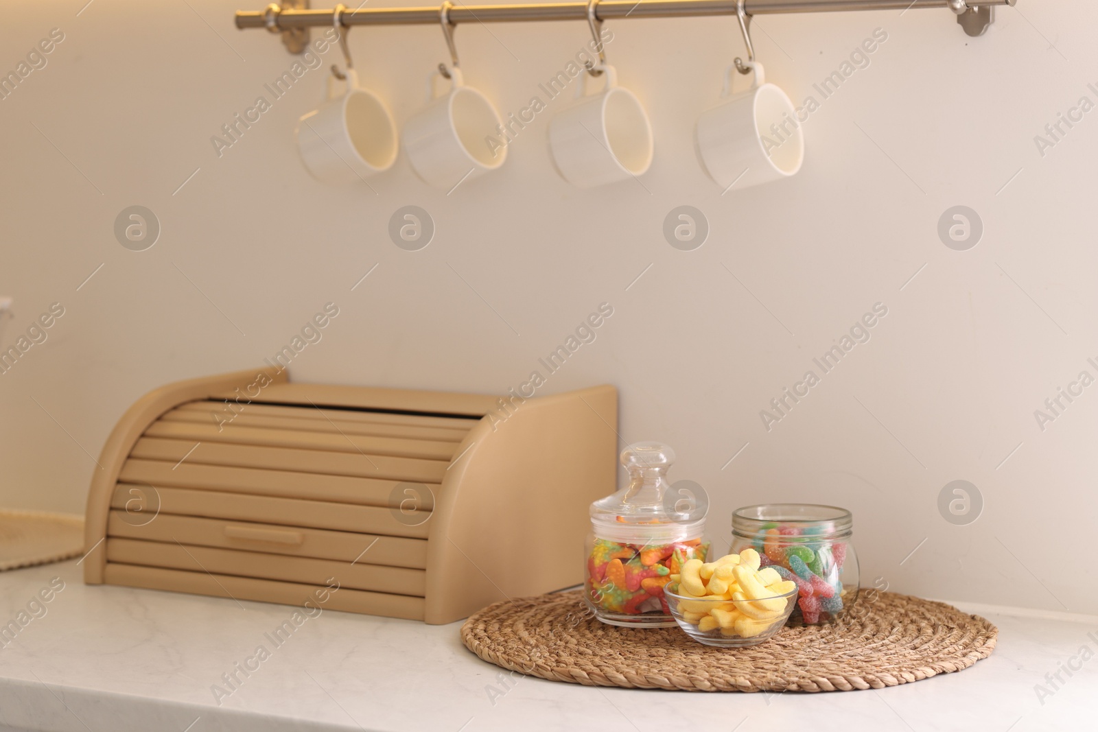 Photo of Tasty gummy candies on white table in kitchen