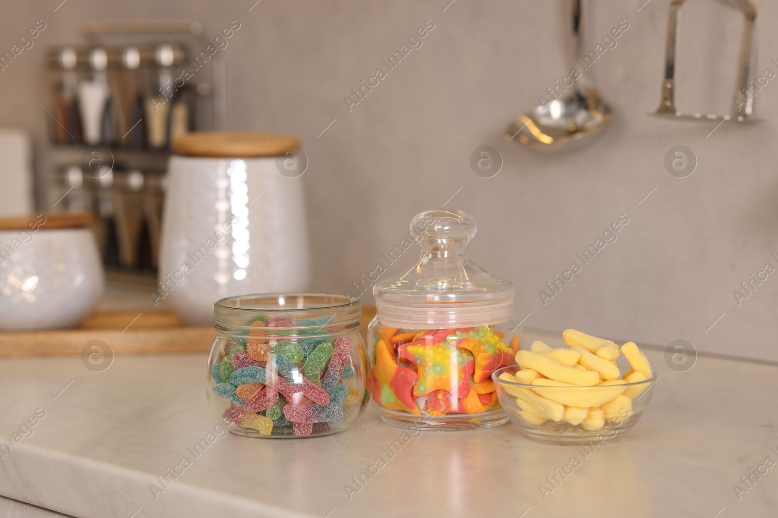 Photo of Tasty gummy candies on white table in kitchen