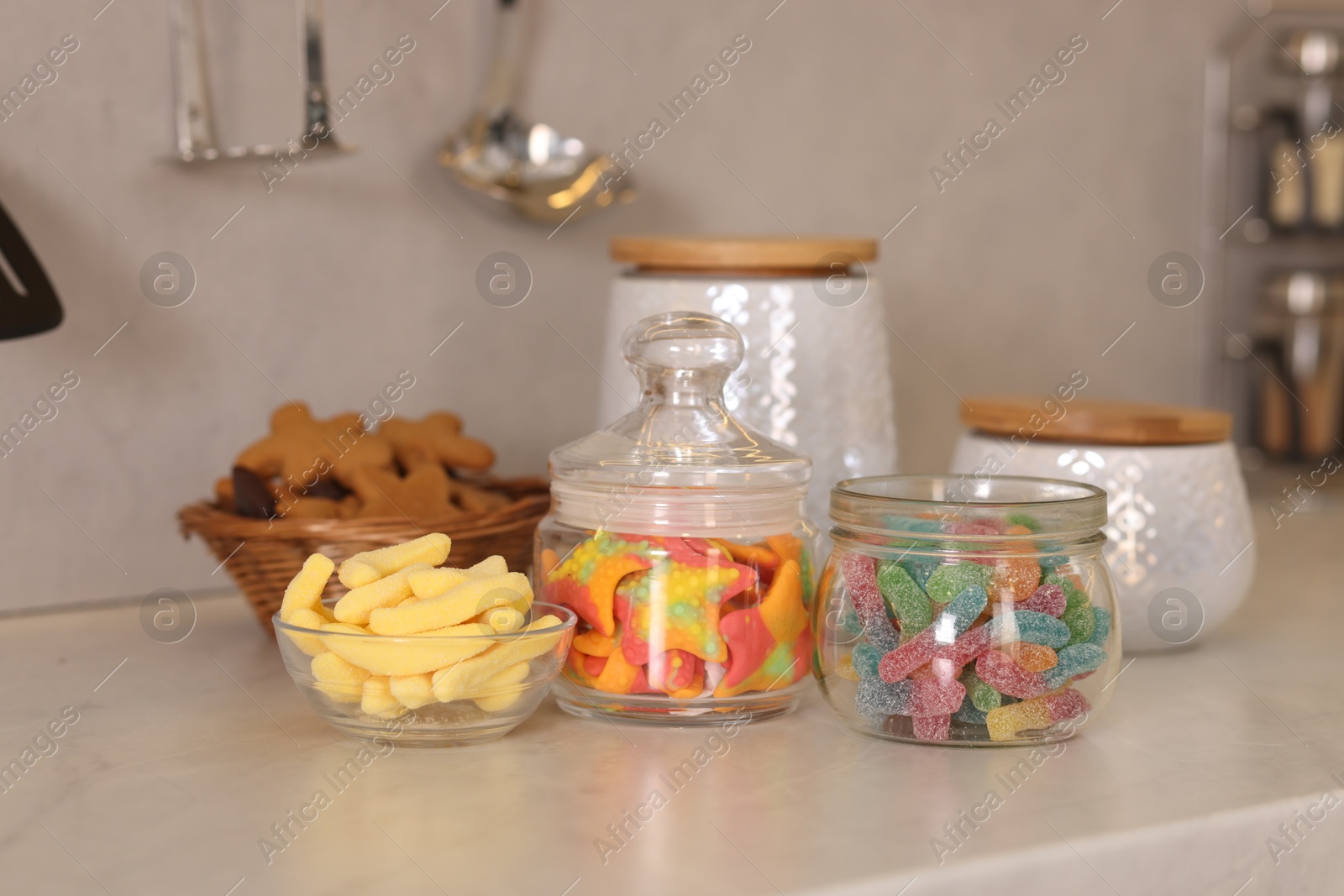 Photo of Tasty gummy candies on white table in kitchen