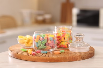 Photo of Tasty gummy candies on white table in kitchen