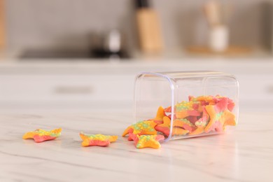 Photo of Gummy candies in glass jar on white marble table indoors