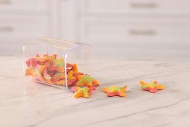 Photo of Gummy candies in glass jar on white marble table indoors