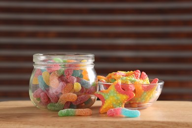 Photo of Tasty gummy candies on wooden table, closeup