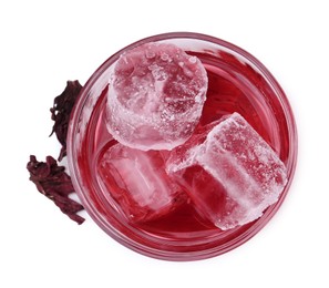 Photo of Delicious hibiscus tea with ice in glass and dry roselle sepals isolated on white, top view