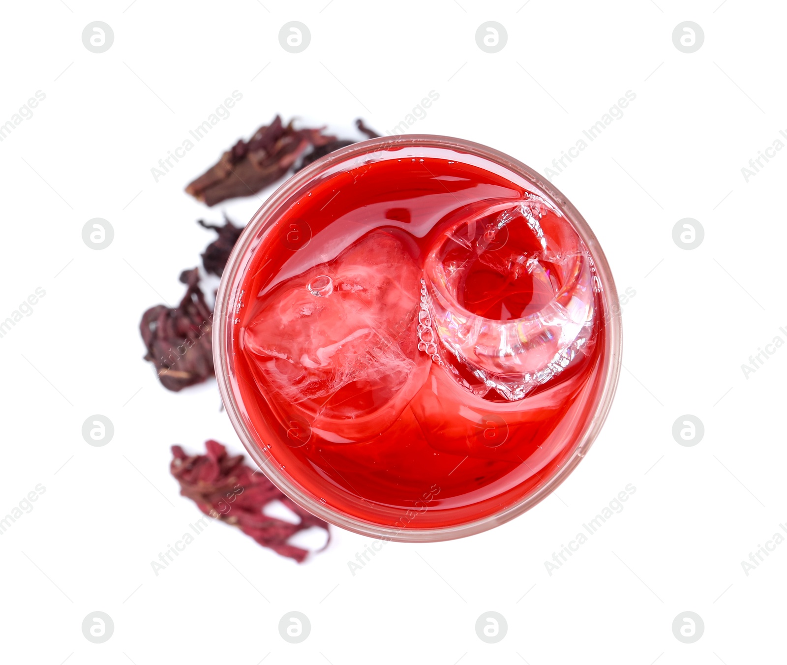 Photo of Delicious hibiscus tea with ice in glass and dry roselle sepals isolated on white, top view