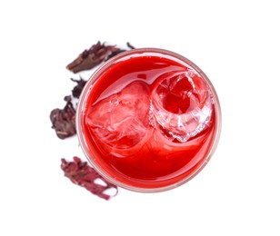 Photo of Delicious hibiscus tea with ice in glass and dry roselle sepals isolated on white, top view