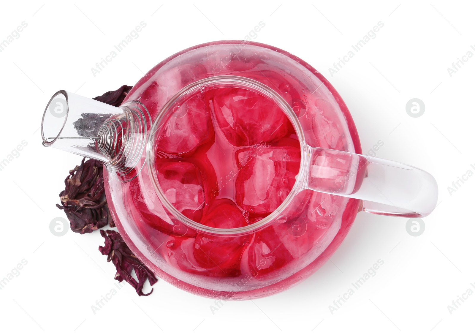 Photo of Delicious hibiscus tea with ice in teapot and dry roselle sepals isolated on white, top view