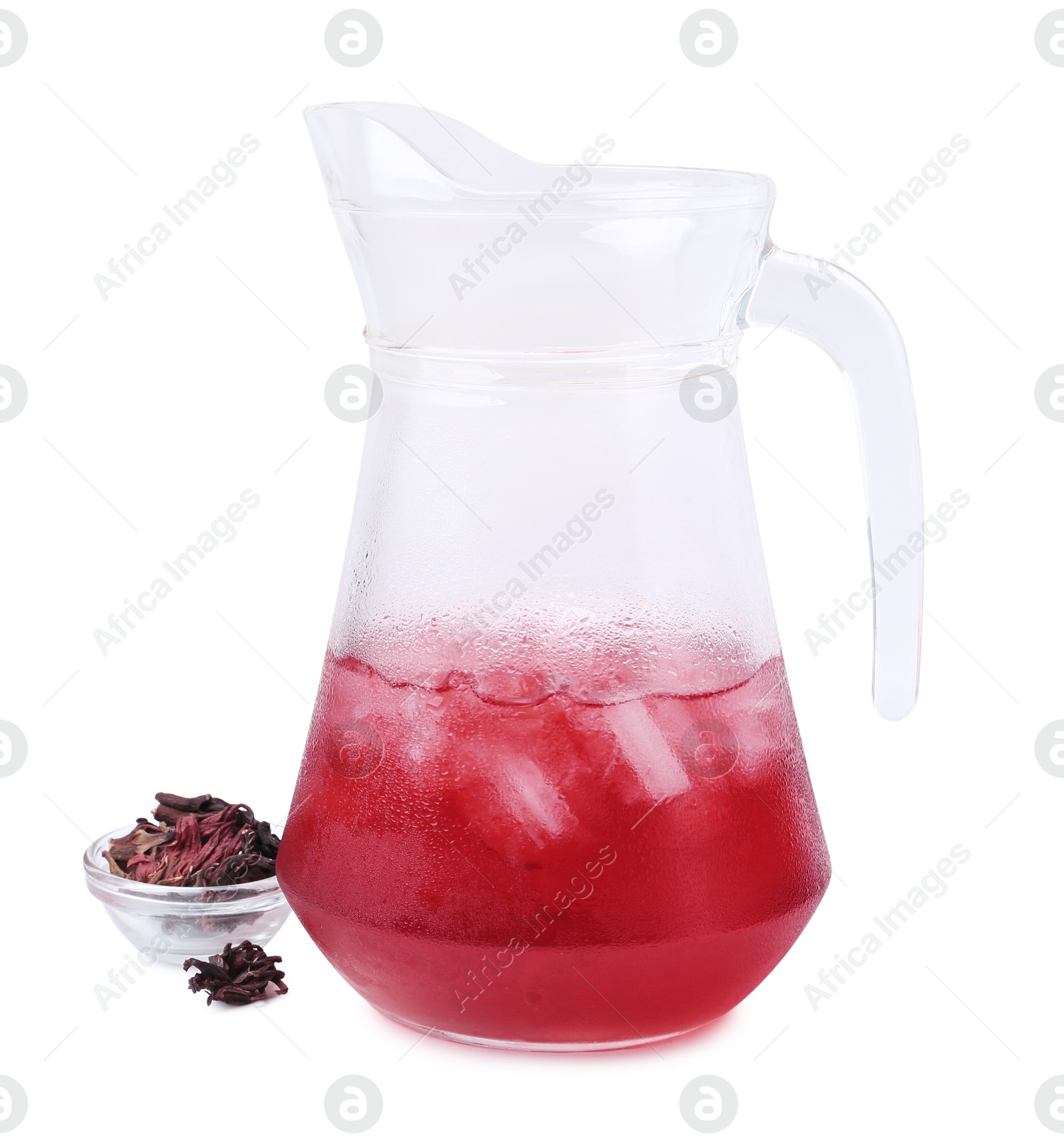 Photo of Delicious hibiscus tea with ice in glass jug and dry roselle sepals isolated on white