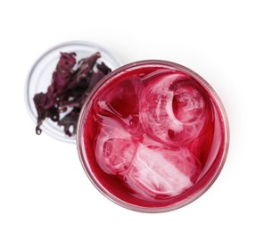 Photo of Delicious hibiscus tea with ice in glass and dry roselle sepals isolated on white, top view