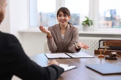 Photo of Man having meeting with professional notary at wooden desk indoors