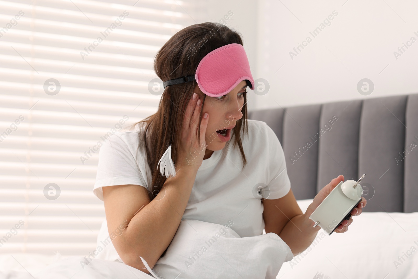 Photo of Overslept woman with alarm clock in bed at home