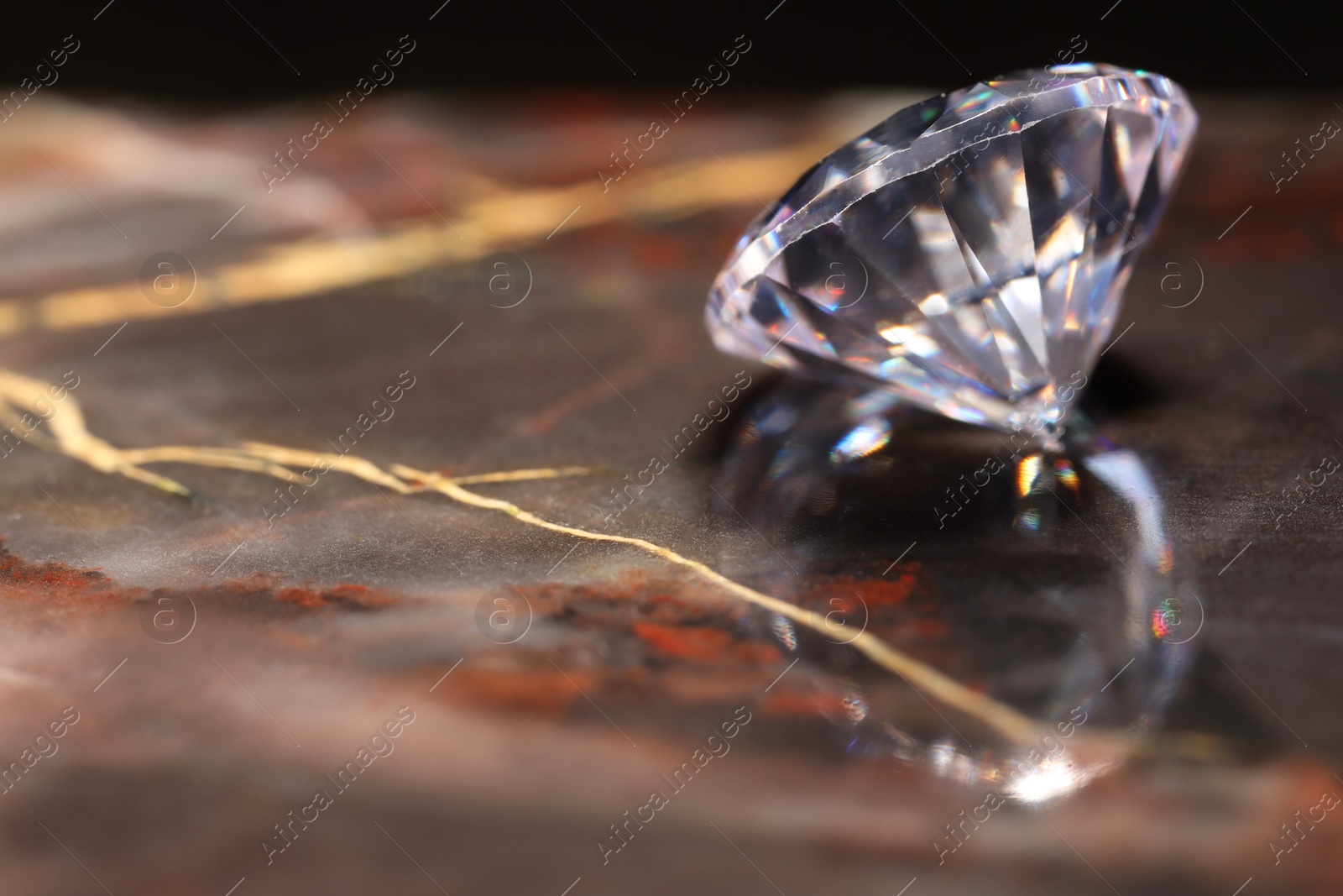 Photo of Beautiful shiny gemstone on brown marble surface, closeup. Space for text