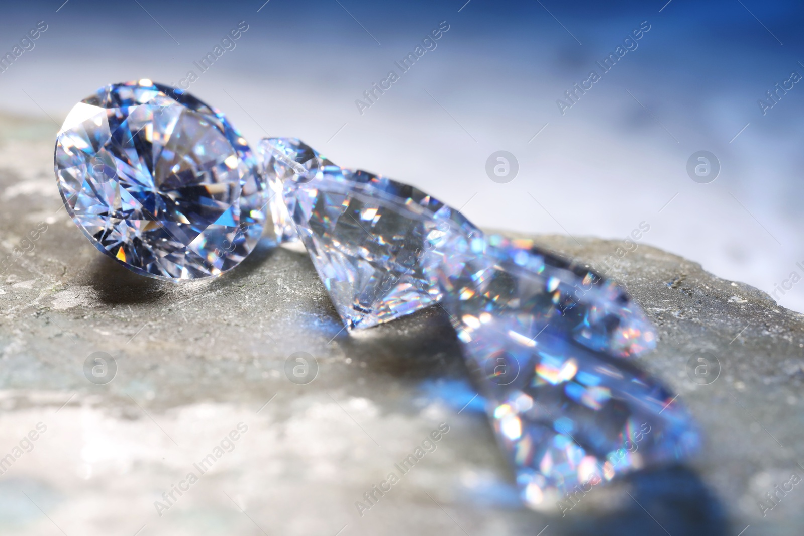 Photo of Beautiful shiny gemstones on stone, closeup view