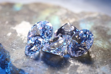 Photo of Beautiful shiny gemstones on stone, closeup view