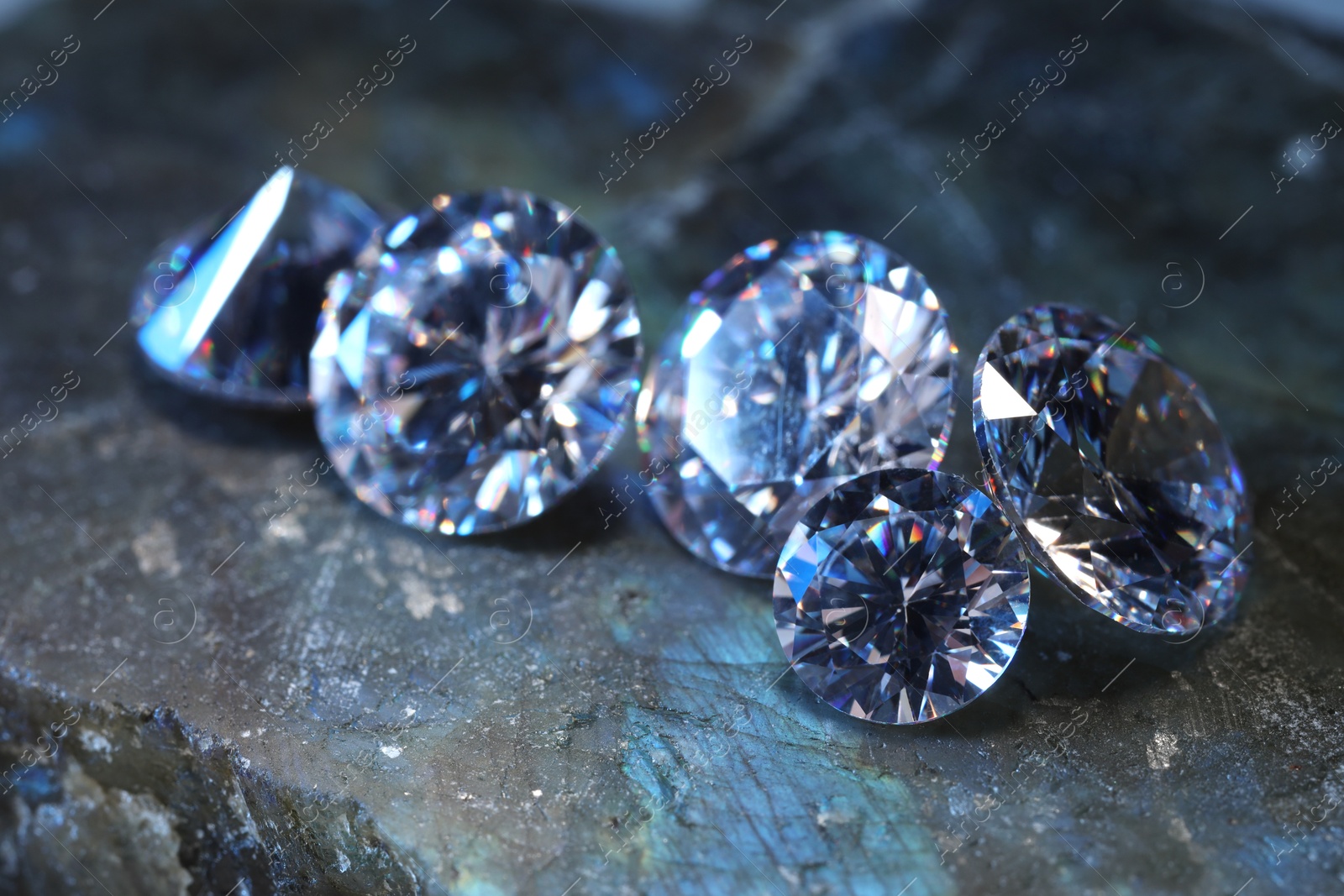 Photo of Beautiful shiny gemstones on stone, closeup view