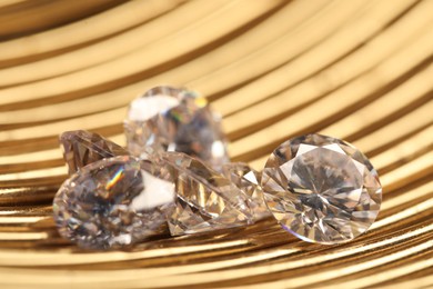 Photo of Beautiful shiny gemstones on golden tray, closeup