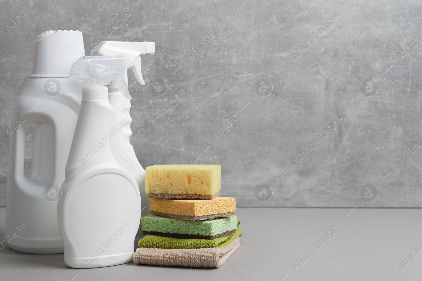 Photo of Eco-friendly cleaning products and supplies on grey table, space for text