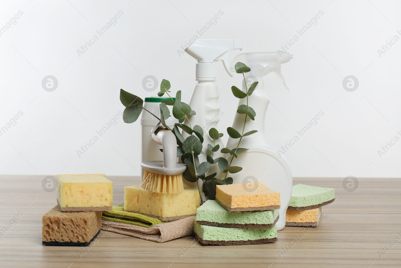 Photo of Eco-friendly cleaning products, supplies and eucalyptus branches on wooden table