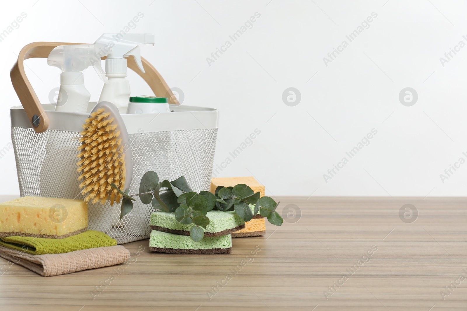 Photo of Eco-friendly cleaning products, supplies and eucalyptus branches on wooden table, space for text