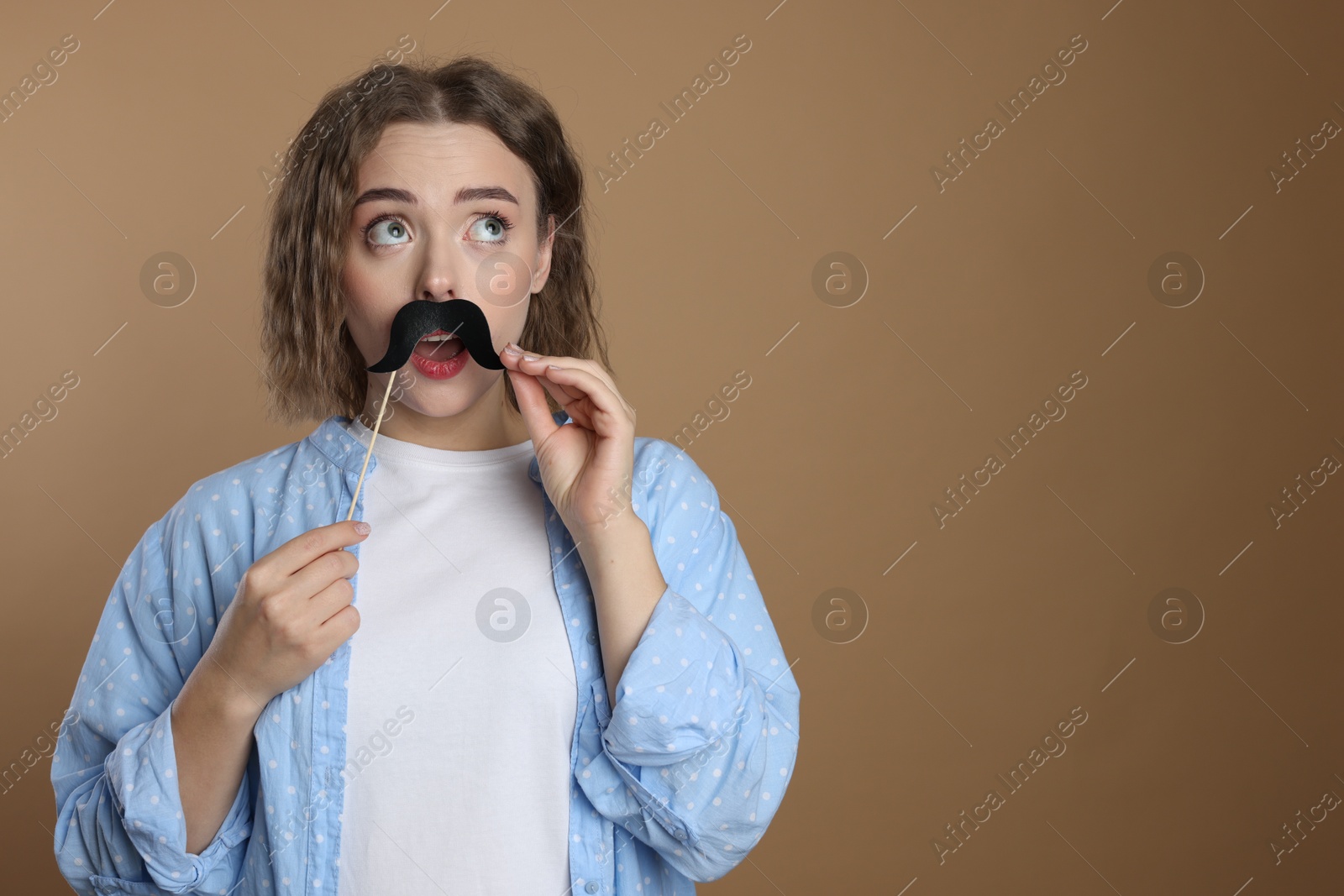 Photo of Woman with fake paper mustache on beige background. Space for text