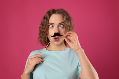 Photo of Funny woman with fake paper mustache on pink background