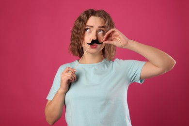 Photo of Funny woman with fake paper mustache on pink background