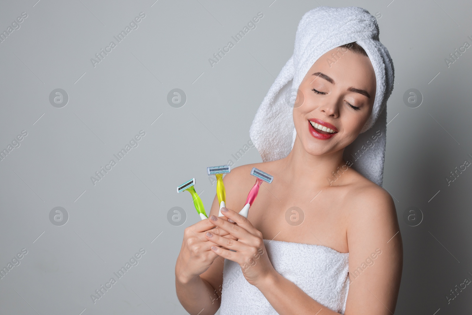 Photo of Happy woman with different razors on grey background, space for text. Hair removal tools