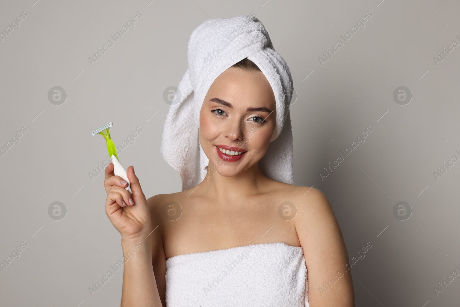 Photo of Happy woman with razor on grey background. Hair removal tool