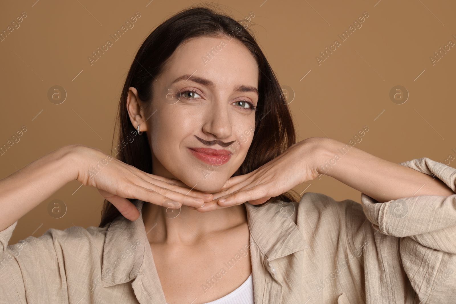 Photo of Funny woman with drawn mustache on brown background