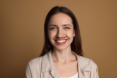 Happy woman with drawn mustache on brown background