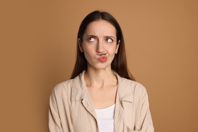 Funny woman with drawn mustache on brown background