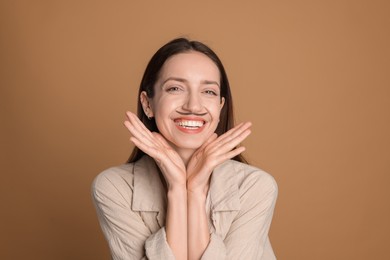 Photo of Happy woman with drawn mustache on brown background