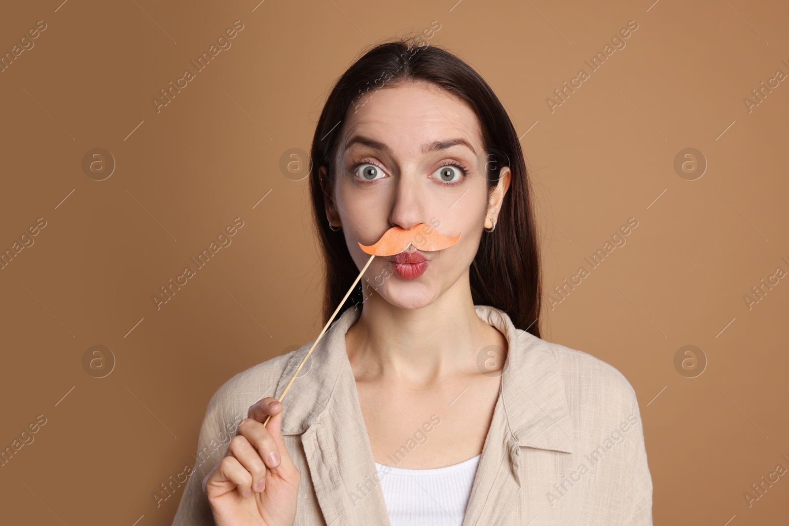 Photo of Funny woman with fake paper mustache on brown background