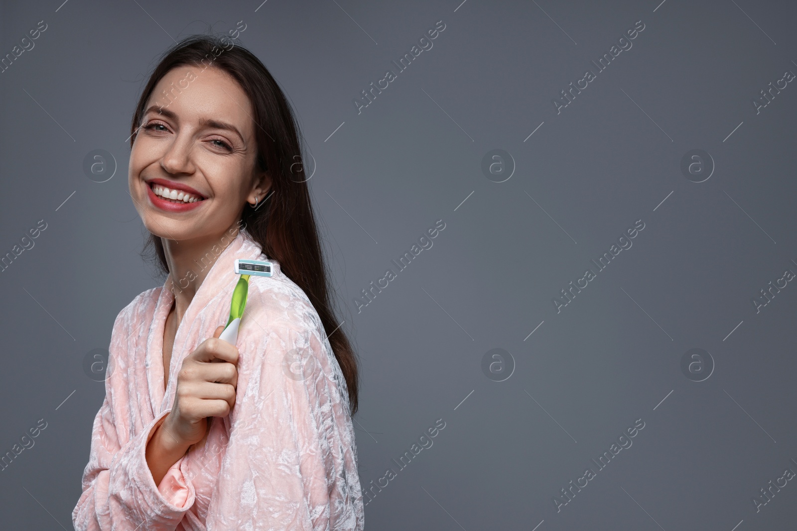 Photo of Happy woman with razor on grey background, space for text. Hair removal tool