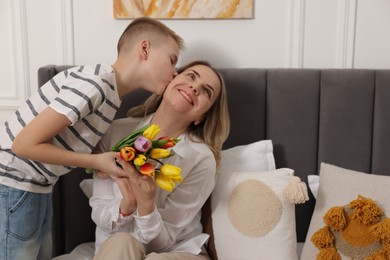 Photo of Happy Mother's Day. Son greeting his mom with flowers at home