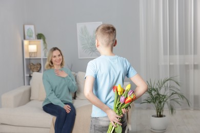 Photo of Happy Mother's Day. Son surprising his mom with flowers at home, selective focus